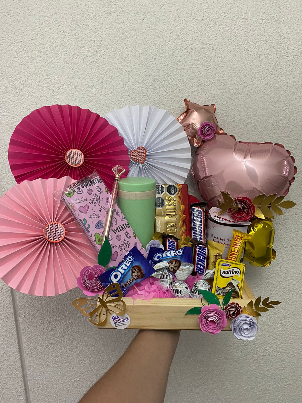 Arreglo de regalo con rosetas y dulces
