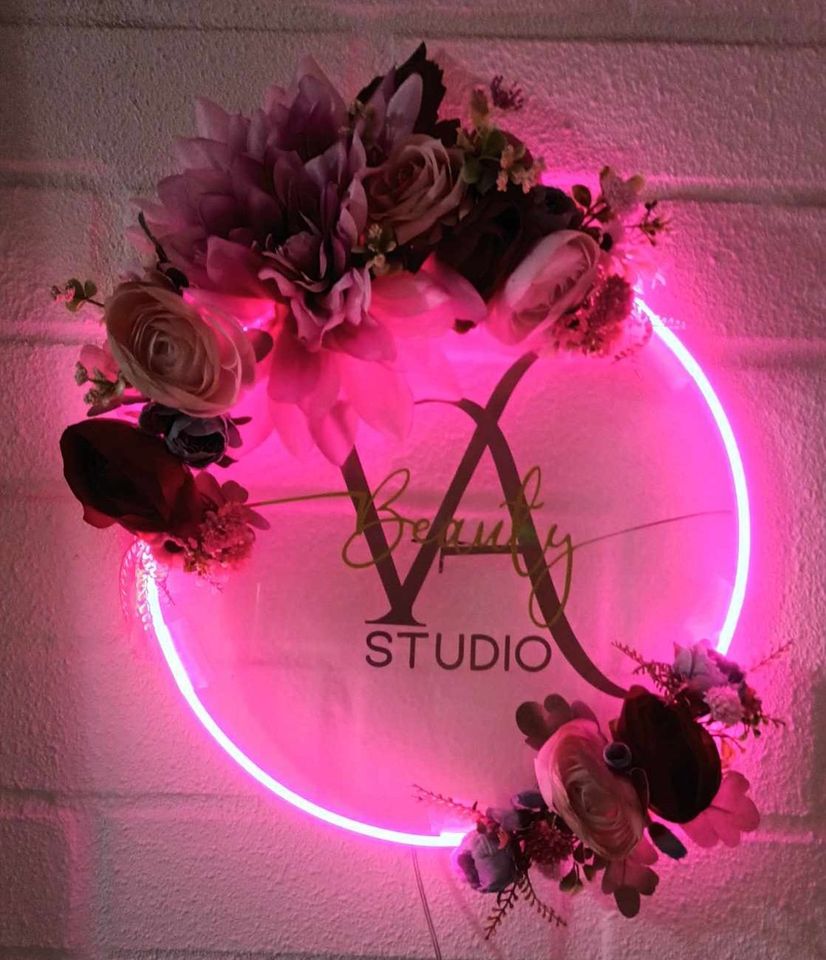 Letrero con luz fucsia y flores